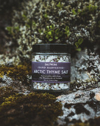 Jar of Saltverk Arctic Thyme Salt on a textured stone surface