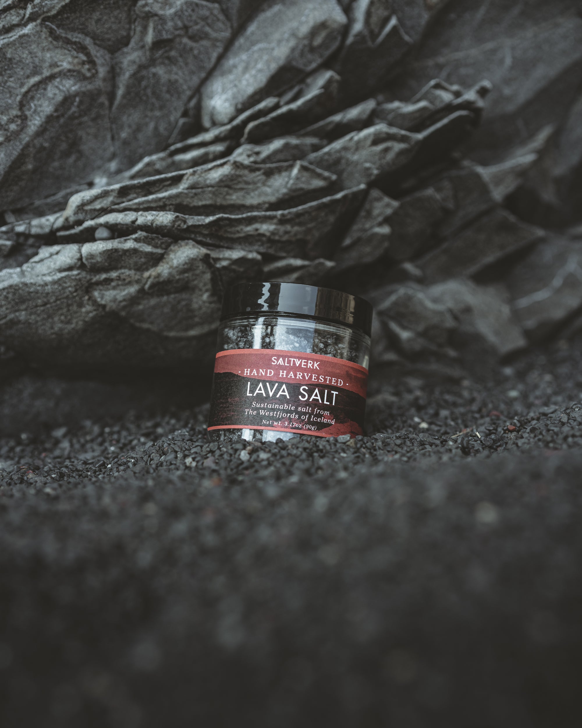 Jar of lava salt on a dark textured surface