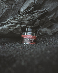 Jar of lava salt on a dark textured surface