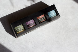 Set of three small containers with labels on a textured surface